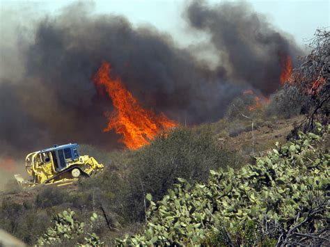 Fire Department Bulldozer Clears Abandoned Cars As Wildfires Threaten Los Angeles