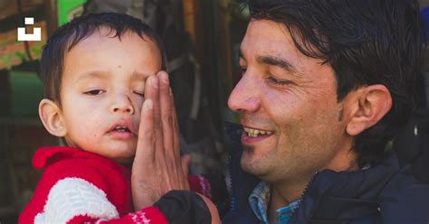 Man In Black Jacket Carrying Baby In Red And White Santa Man In Red And White Photo Free India