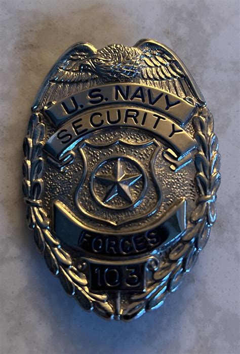 The U S Navy Security Badge Is Shown On A White Table Top With Blue Writing